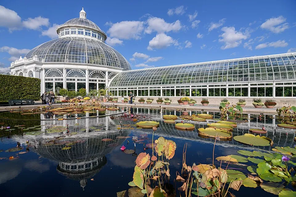 The Enid A. Haupt Conservatory beside a lily pond at the New York Botanical Garden
