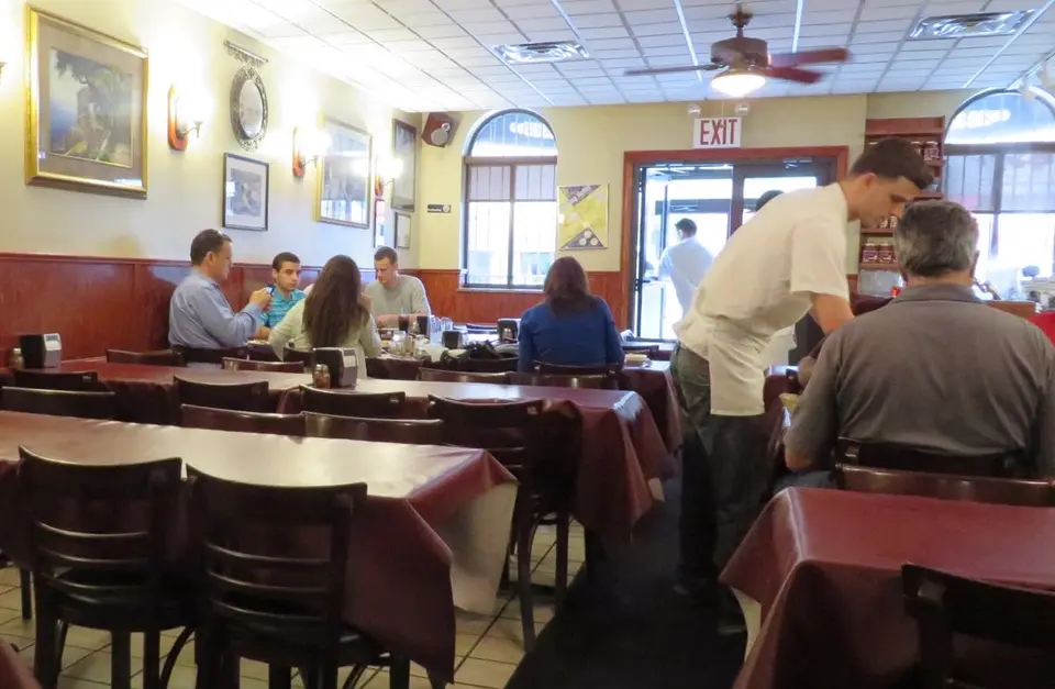 Red-covered tables and a waiter in Dominick's dining room